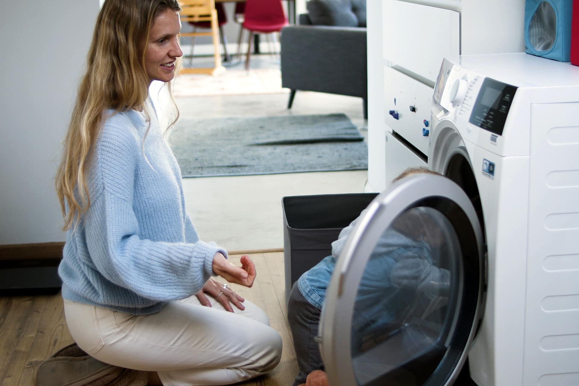 A parent and child at the washing machine